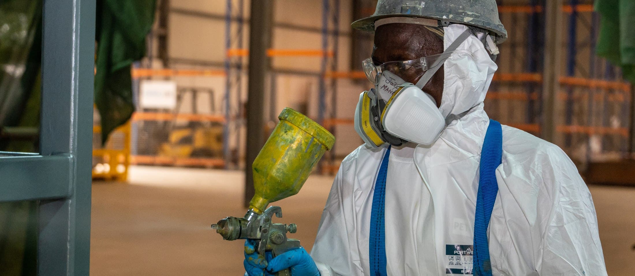 Technician spray-coating a component in the workshop